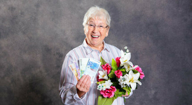 Starsza kobieta dzieli się wygraną z kasjerem, który poradził jej kupić los na loterii